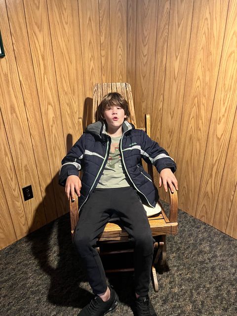 Trying out a chair during the visit.