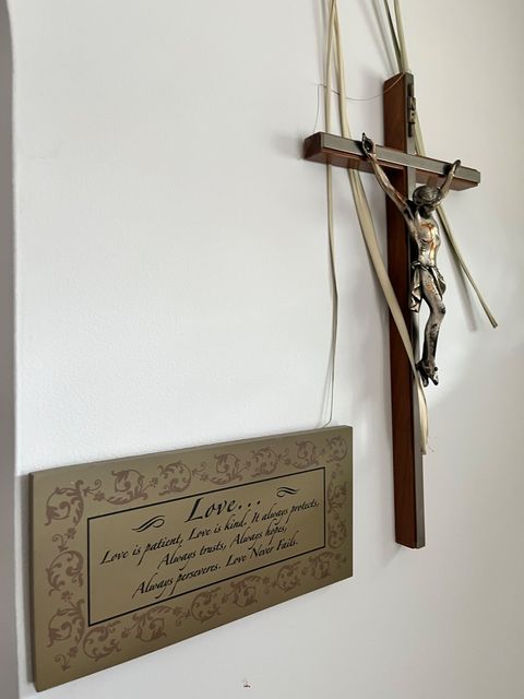A crucifix and a plaque on an interior wall.